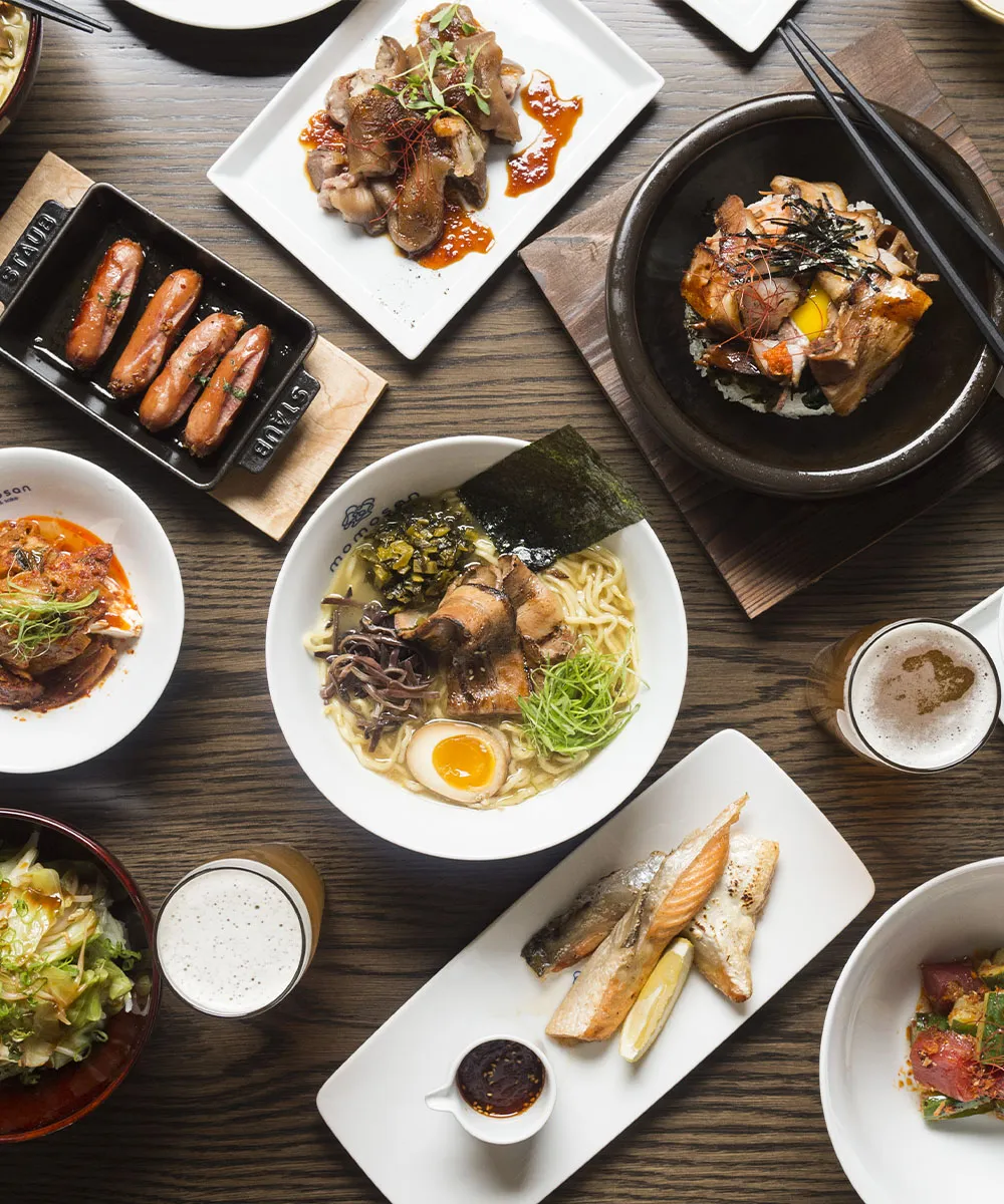 top-down view of ramen, beef, appetizers, and beer