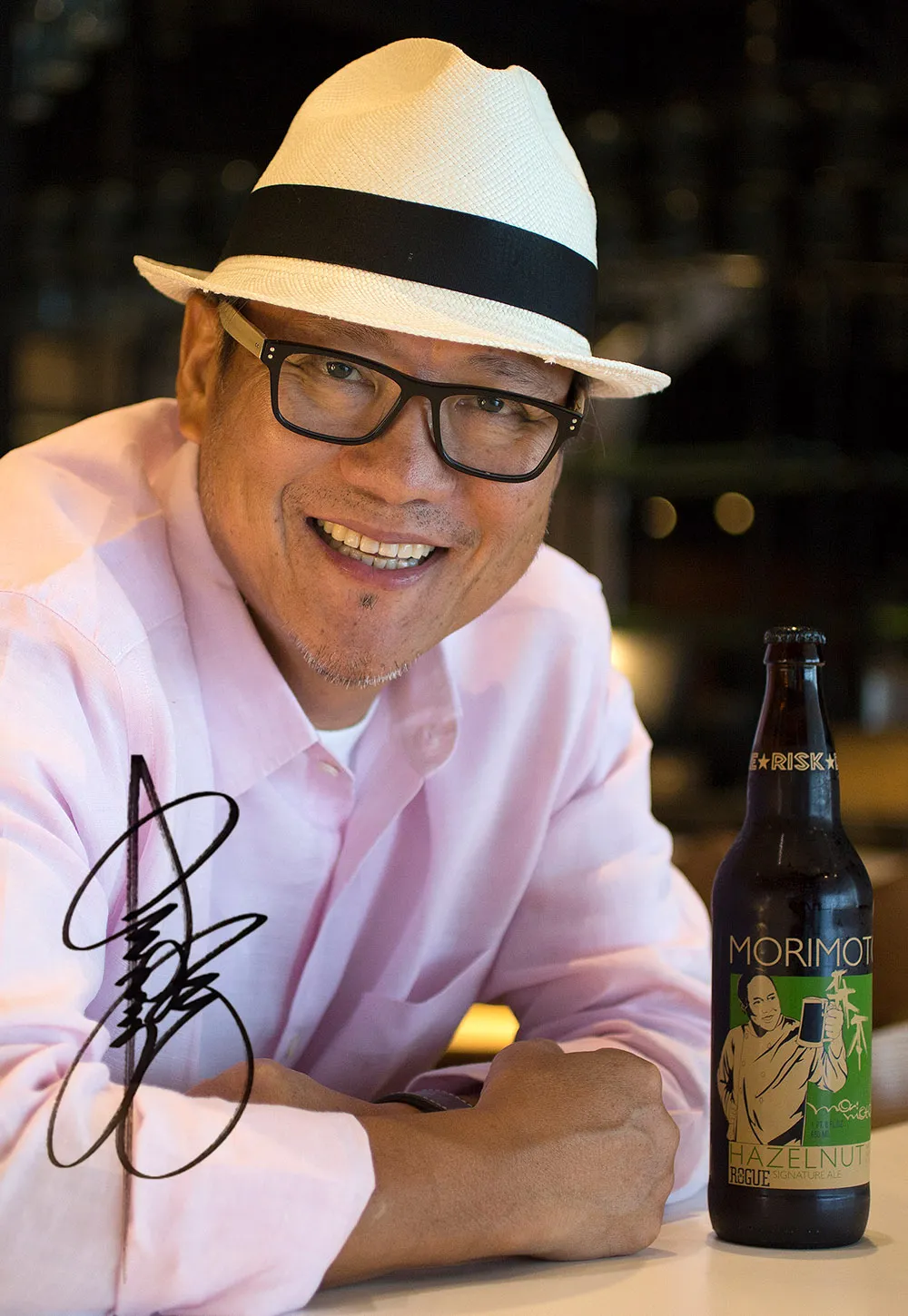 Iron Chef Masaharu Morimoto next to Morimoto Hazelnut Signature Ale with autograph